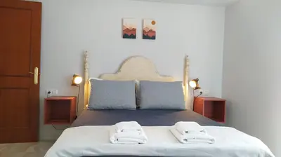 a bedroom with a bed with two towels on it at Sherryflat Claveles - Parking in Jerez de la Frontera