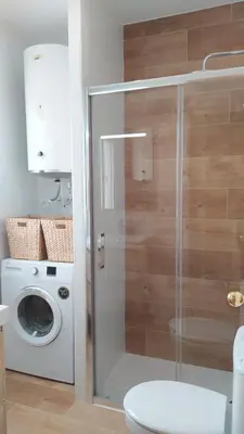 a bathroom with a toilet and a washing machine at Sherryflat Fontana in Jerez de la Frontera