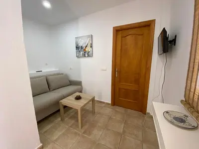 a living room with a couch and a wooden door at Alojamiento Rural Al´Mare in Conil de la Frontera