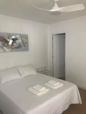 a bedroom with a white bed with two towels on it at Alojamiento Rural Al´Mare in Conil de la Frontera