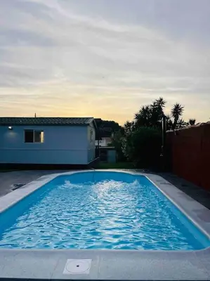 a large blue swimming pool in front of a house at Alquiler de casa Vacacional in Chiclana de la Frontera