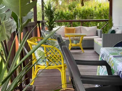 a patio with yellow chairs and a couch on a deck at Alquiler de casa Vacacional in Chiclana de la Frontera
