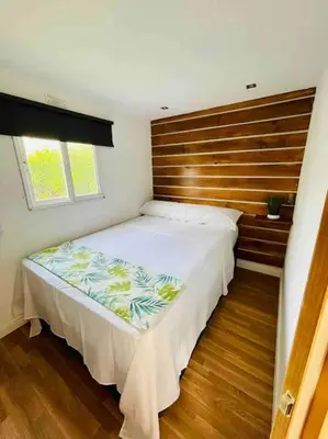 a bedroom with a large bed with a wooden headboard at Alquiler de casa Vacacional in Chiclana de la Frontera