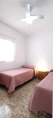 a bedroom with two beds and a ceiling fan at Casa con piscina privada y jardín in Chiclana de la Frontera