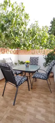 a patio with a table and two chairs at Casa con piscina privada y jardín in Chiclana de la Frontera