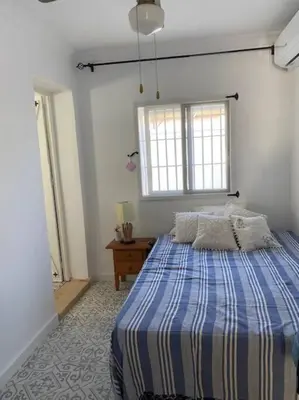 a bedroom with a blue and white bed and a window at Casa im andalusischen Look in der Nähe von Chipiona in Costa Ballena