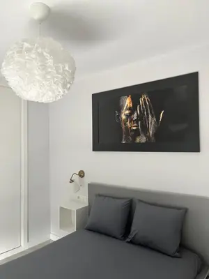 a living room with a bed and a tv on the wall at Piso Palacios in El Puerto de Santa María