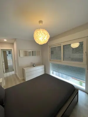 a bedroom with a black bed and a chandelier at Piso Palacios in El Puerto de Santa María