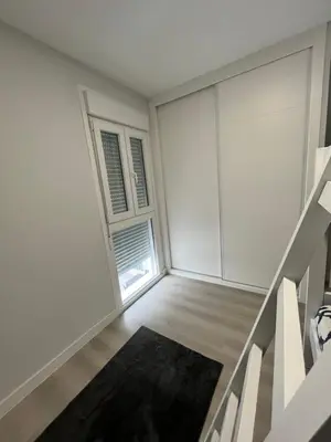 an empty living room with stairs and a window at Piso Palacios in El Puerto de Santa María